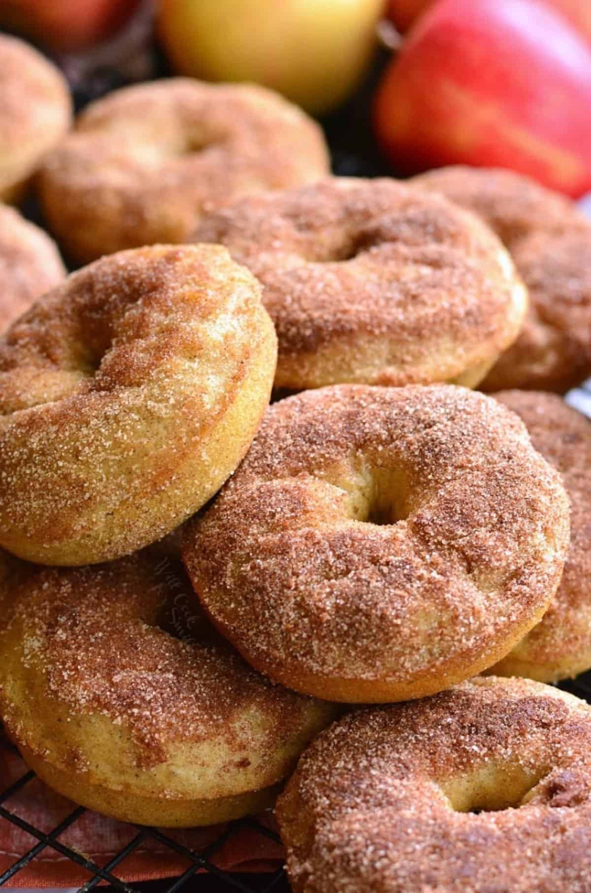 A stack of apple pie donuts on a wire rack.