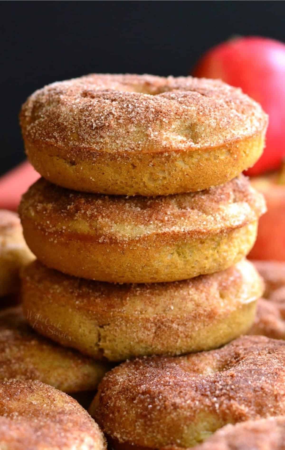 Apple baked donuts stacked up on top of each other.