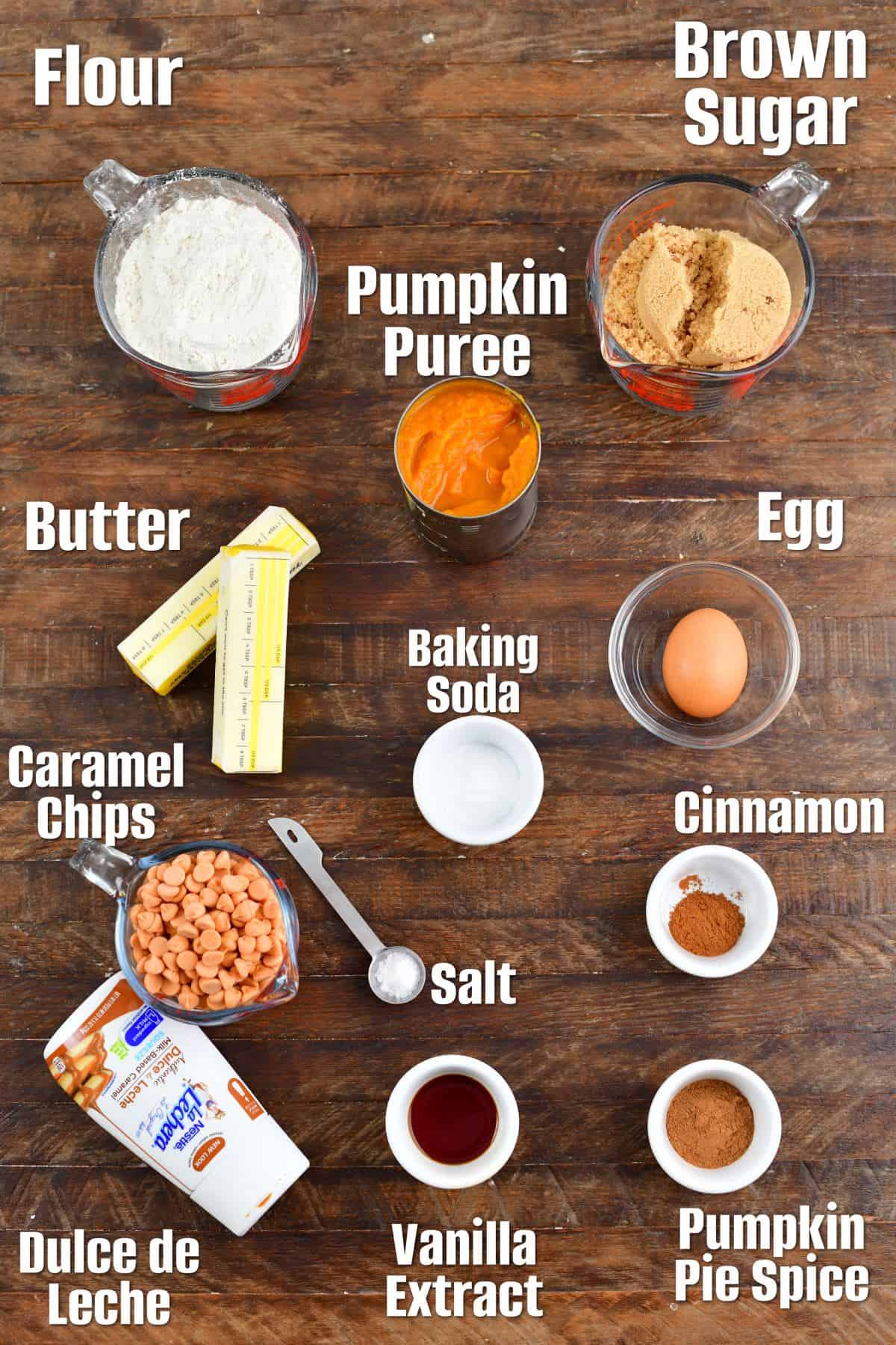 Labeled ingredients for caramel pumpkin blondies on a wood surface.