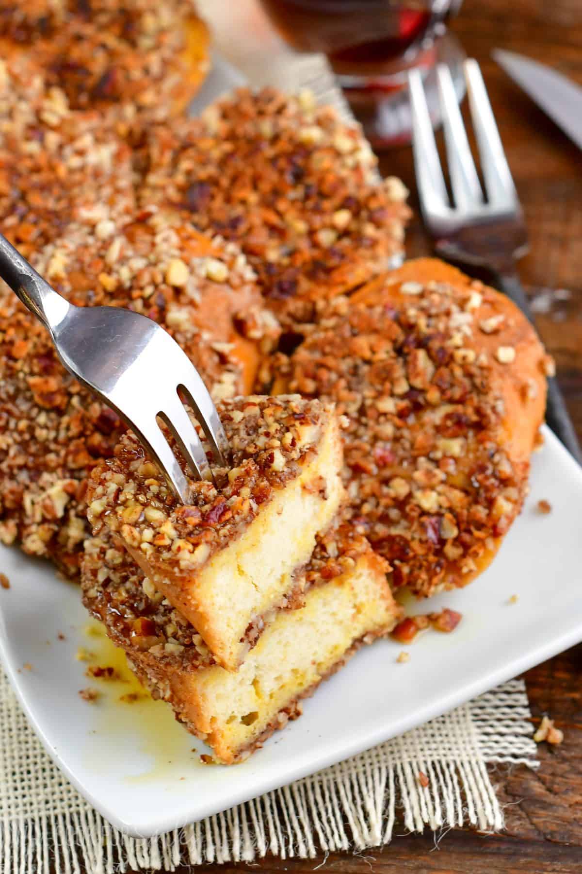 Pecan Crusted French Toast on a plate with a slice cut in half and on a fork.