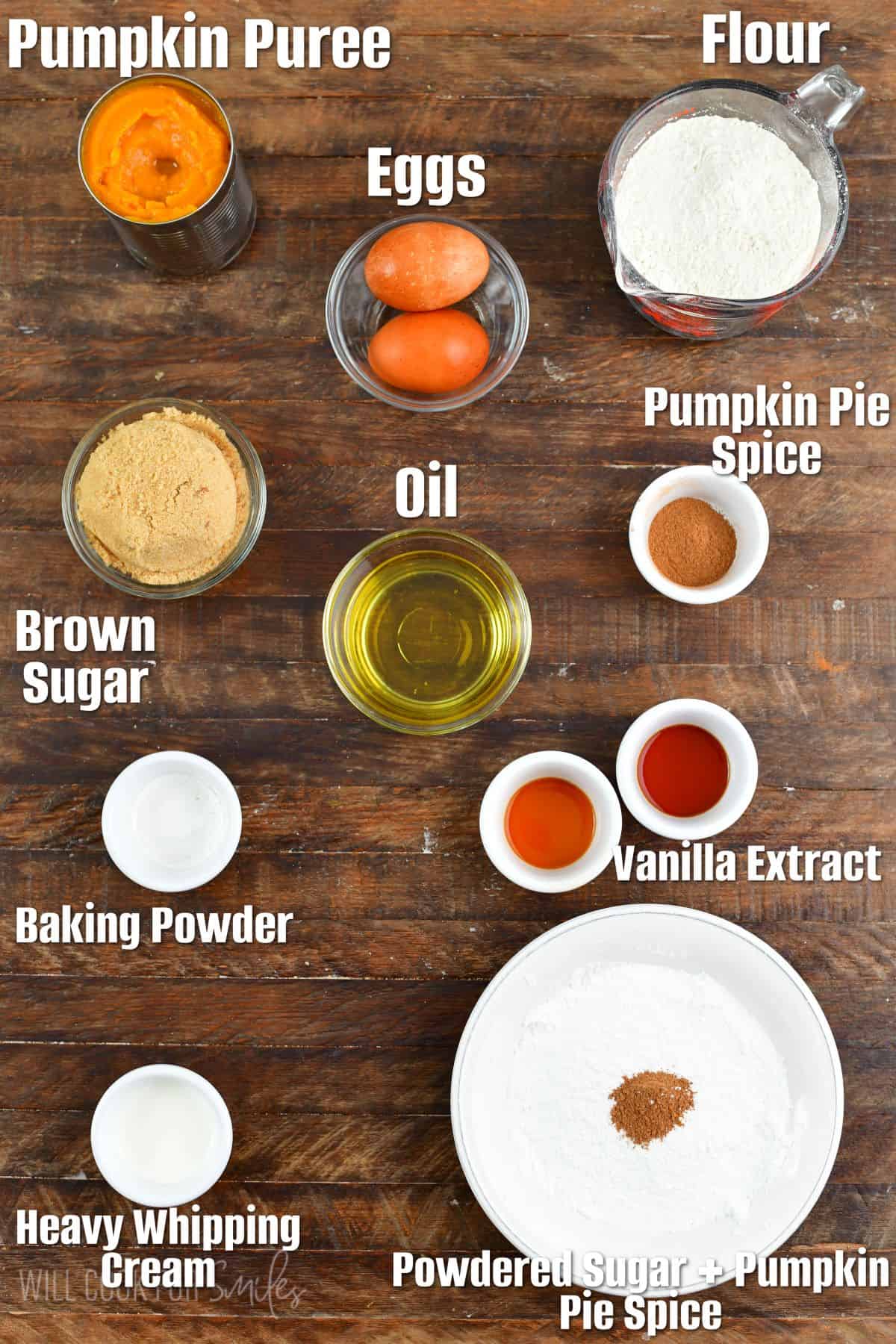 Labeled ingredients for pumpkin donuts on a wood surface.