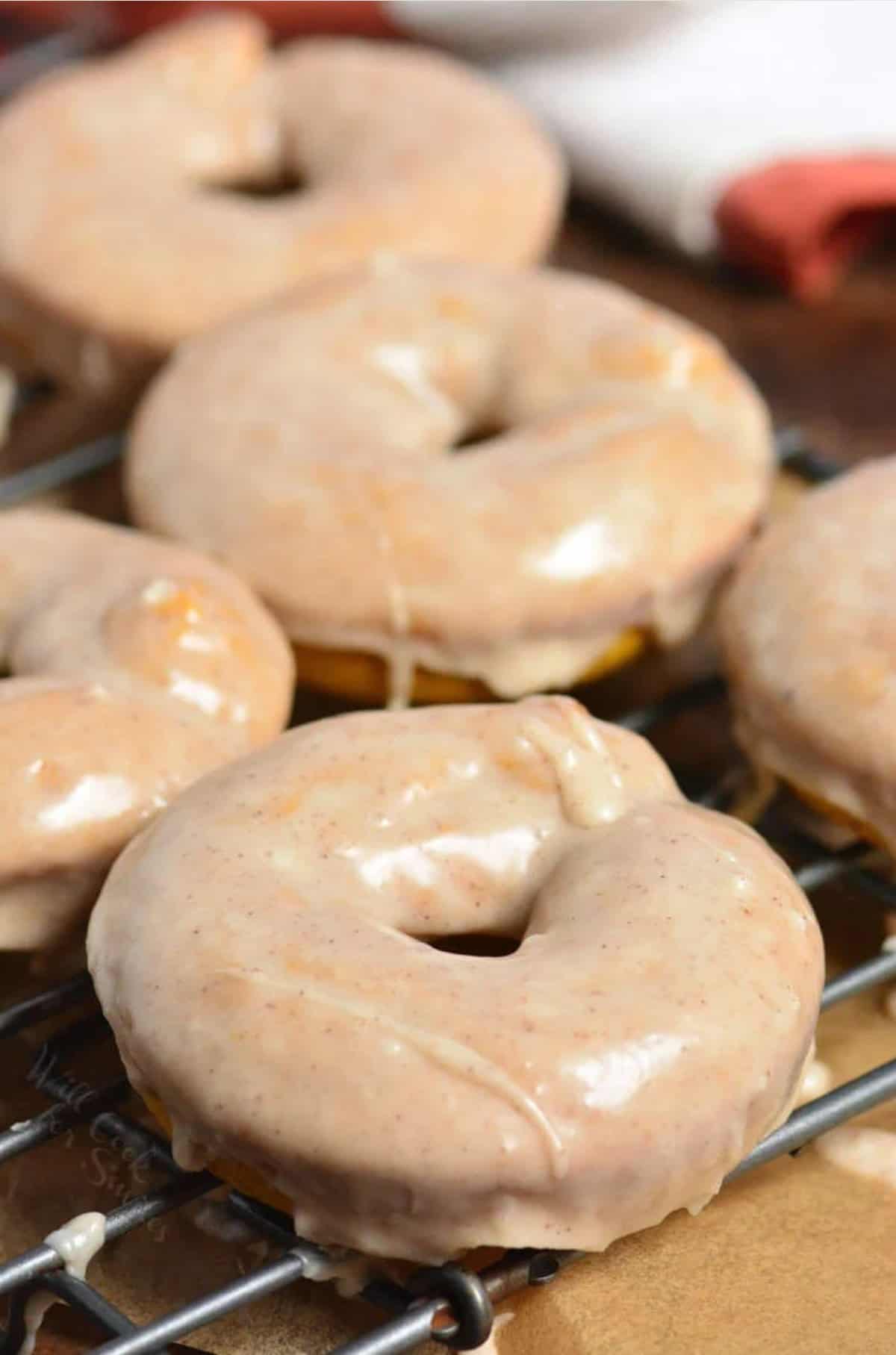 pumpkin glazed donuts on a wire rack.