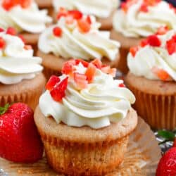 Strawberry Cupcakes on a wire rack with one of the cupcakes unwrapped.