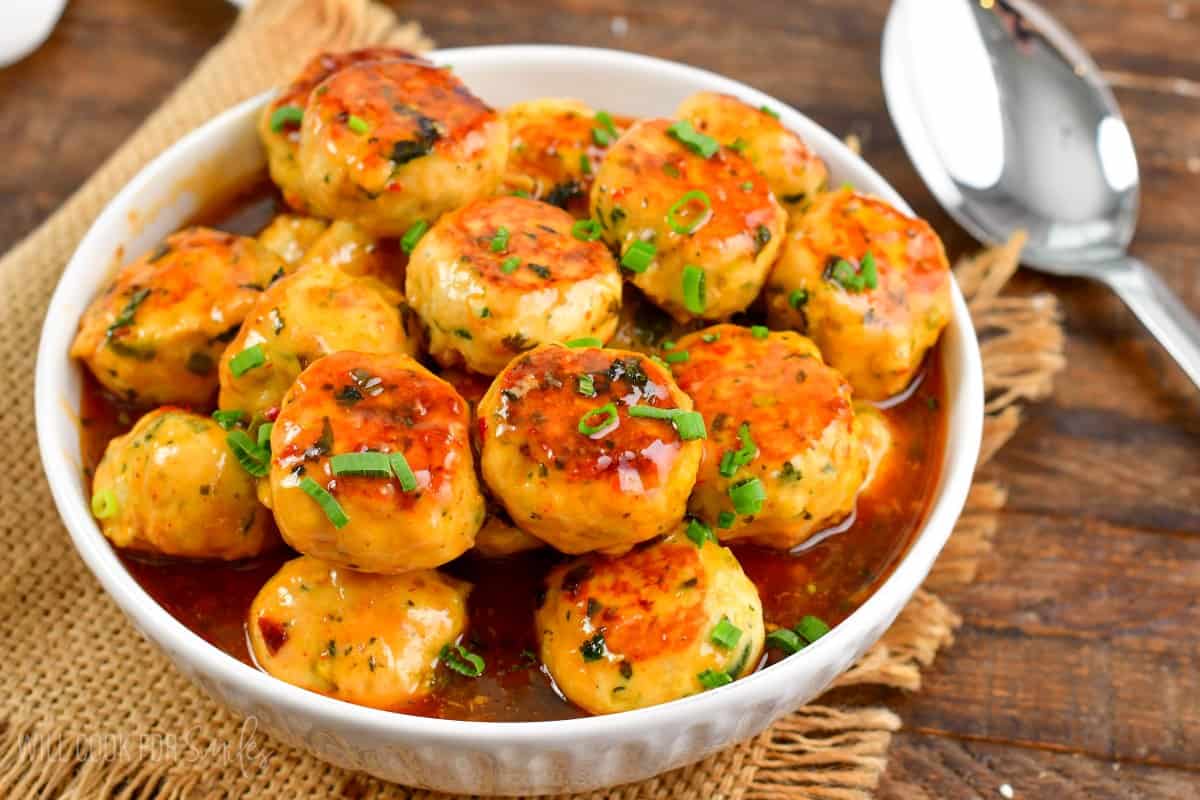 Thai sweet chili meatballs in a bowl on burlap placemat.