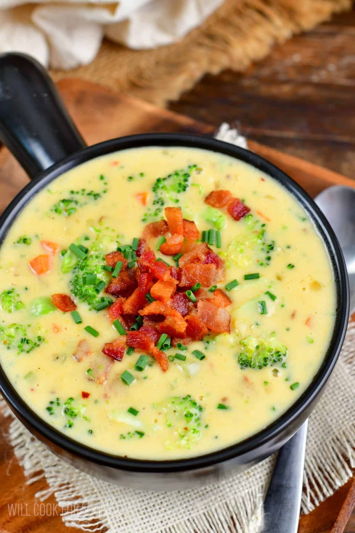 Bacon Broccoli Cheese Soup in a bowl with a spoon to the right.