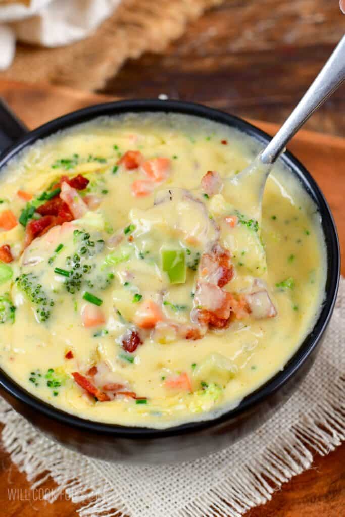 Bacon Broccoli Cheese Soup being scooped up with a spoon.