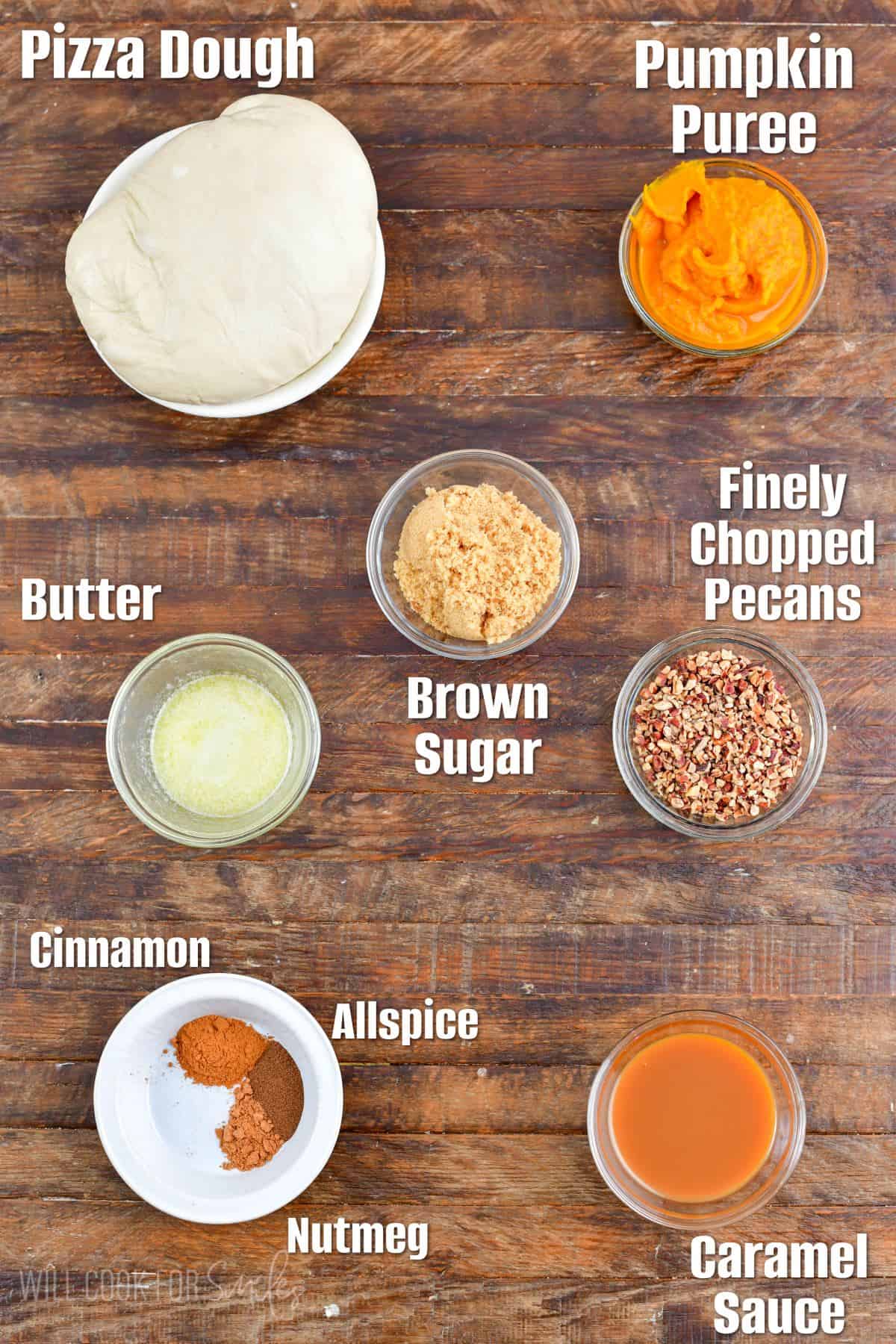 labeled ingredients to make pumpkin pull apart bread on wooden board.