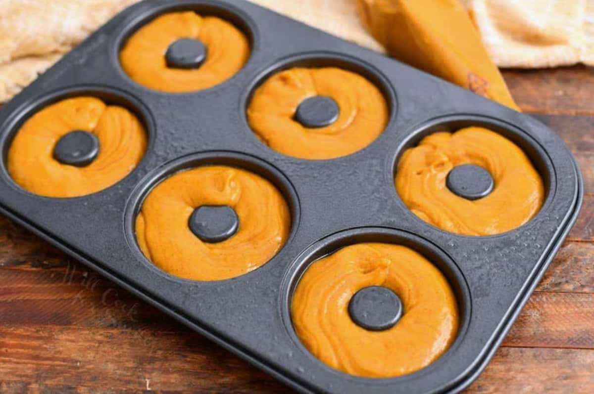 donut pan filled with raw batter in pumpkin donut for a baked donut recipe.