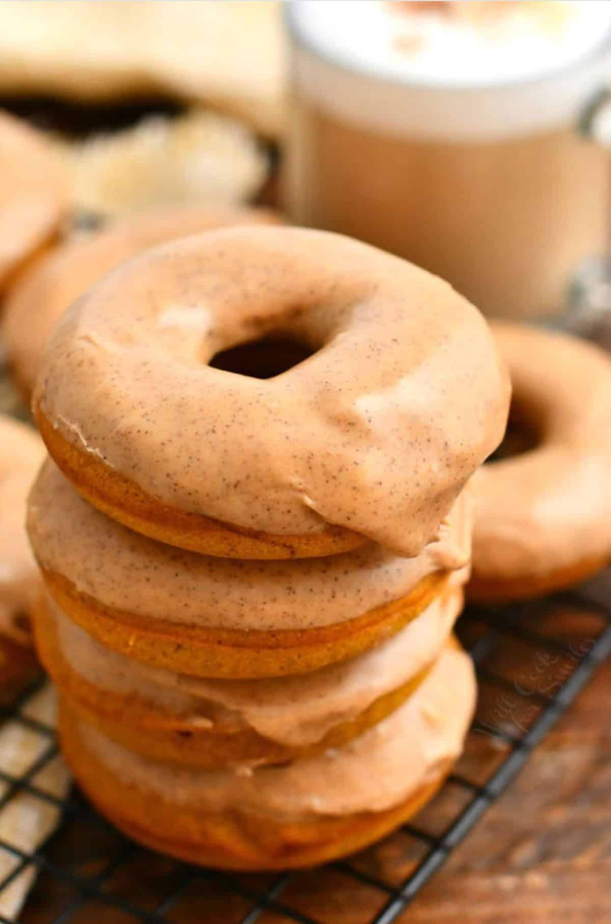 stack of four pumpkin spice baked donuts with glaze on top.