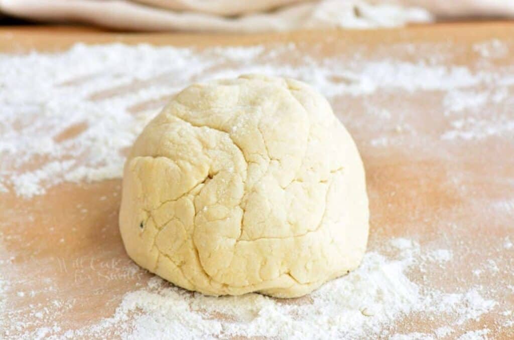 a ball of dough for cauliflower gnocchi on floured surface.