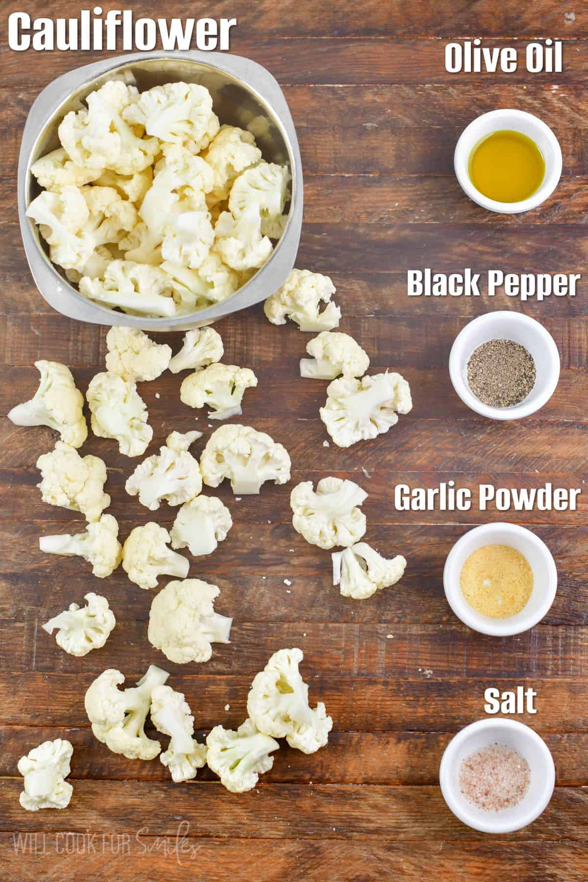 labeled ingredients to make easy roasted cauliflower on the wooden board.