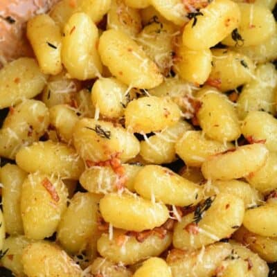 lots of gnocchi in the skillet mixed with garlic butter and parmesan cheese.