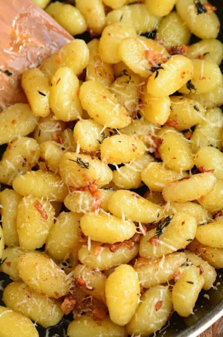 lots of gnocchi in the skillet mixed with garlic butter and parmesan cheese.