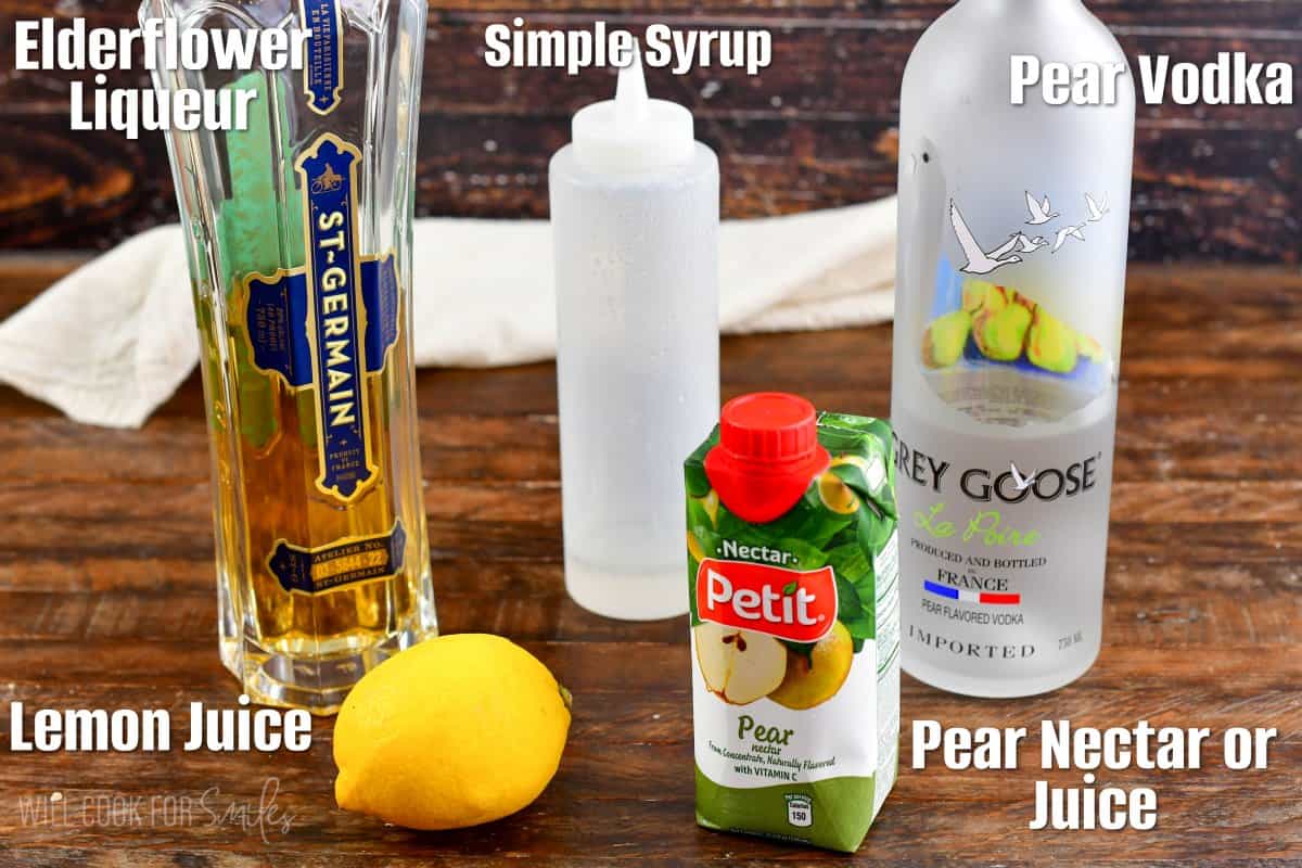 labeled ingredients to make pear martini on a wooden board.