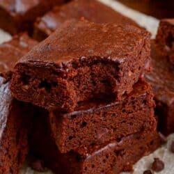 Pumpkin brownies stacked up with the a bite out of the top brownie.