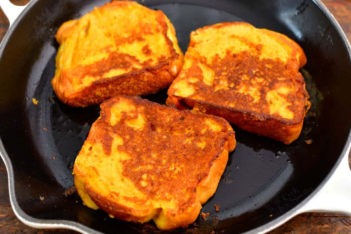 three cooked sliced of French toast on a cooking pan.