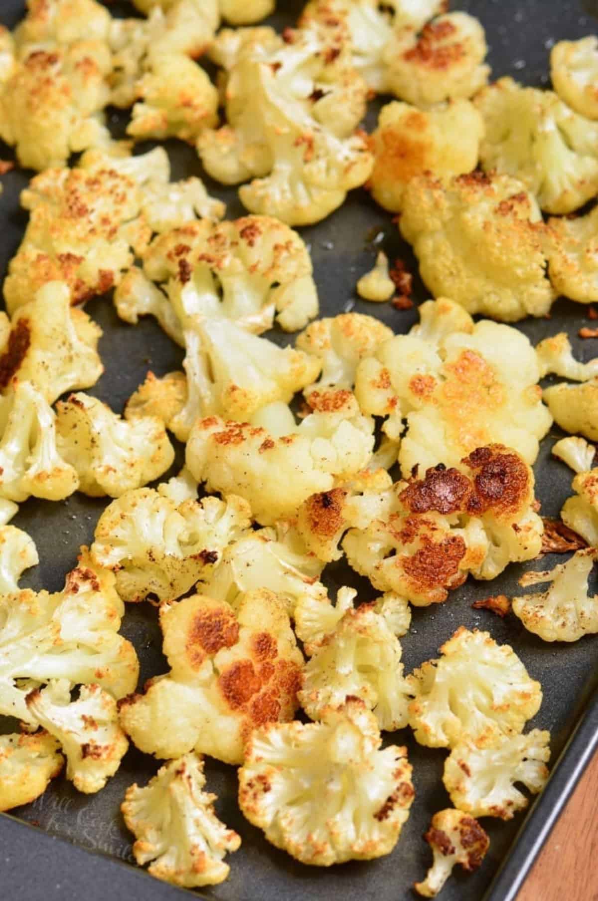 Roasted cauliflower florets on a baking sheet.