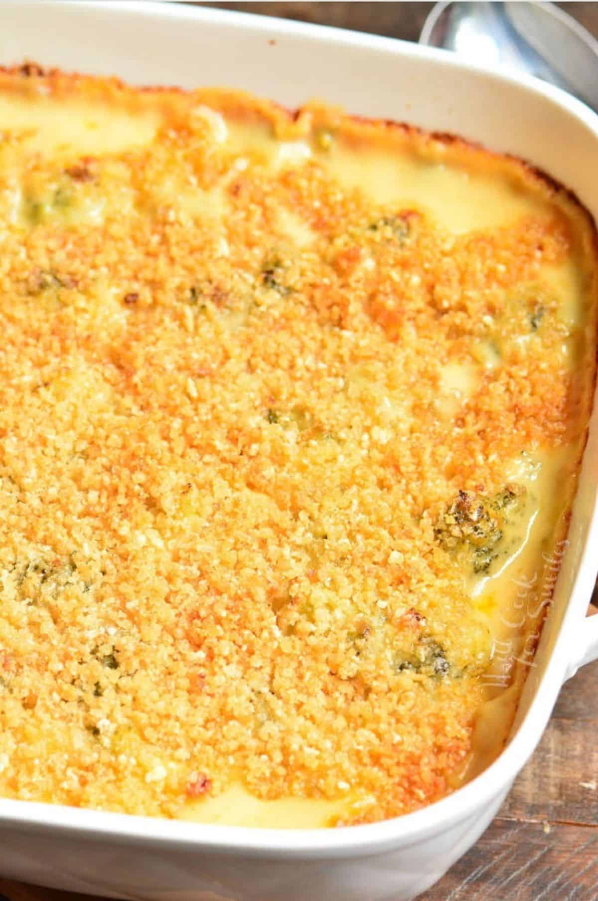 baked broccoli cheese casserole in a white baking dish.