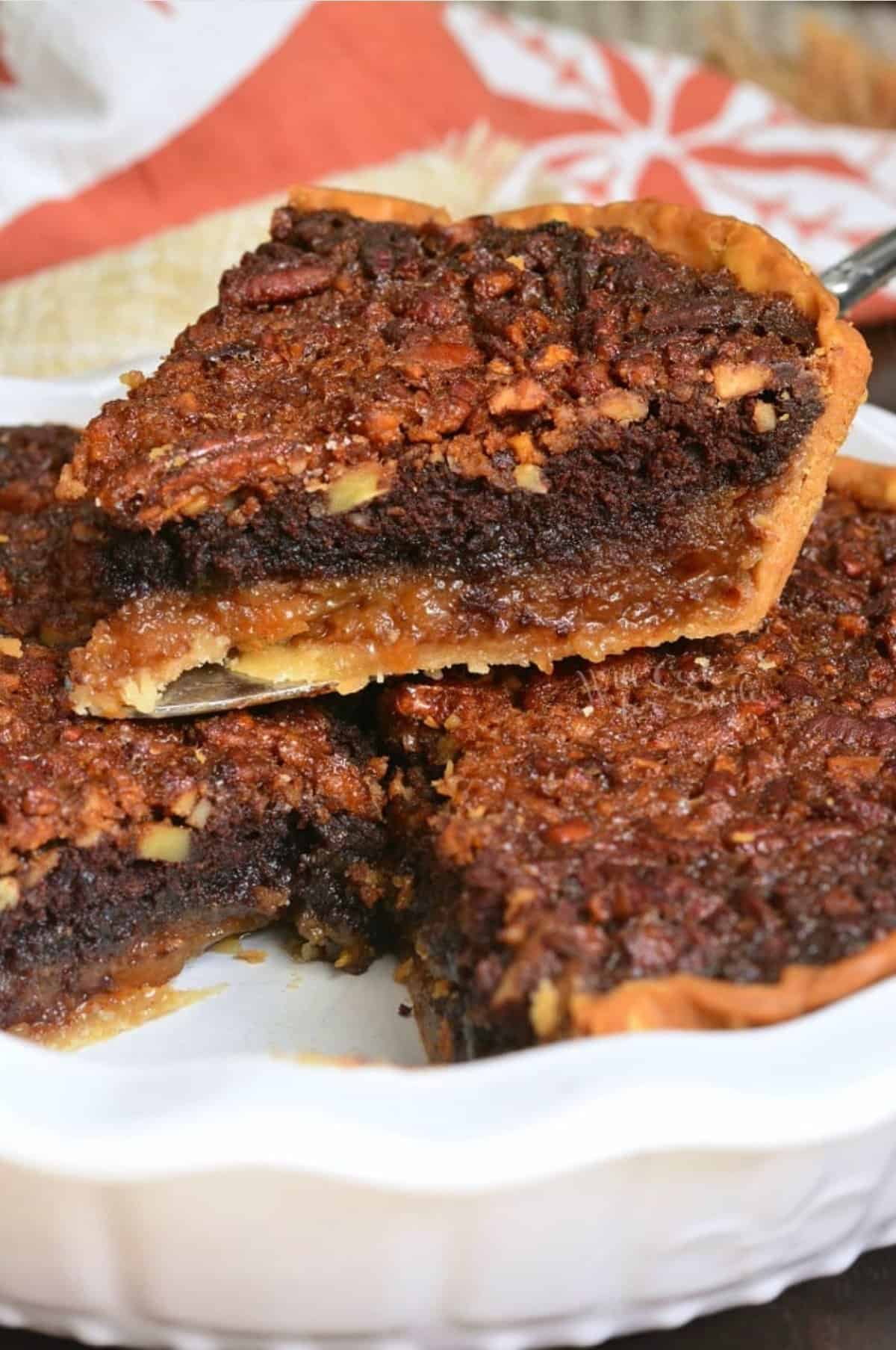 a lice of pecan brownie pie on to pf the rest of the pie in a pie dish.