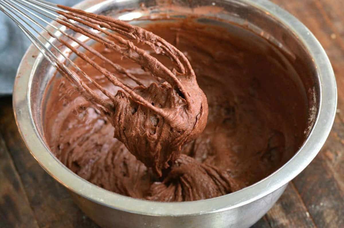 whisking brownie batter in a mixing bowl.