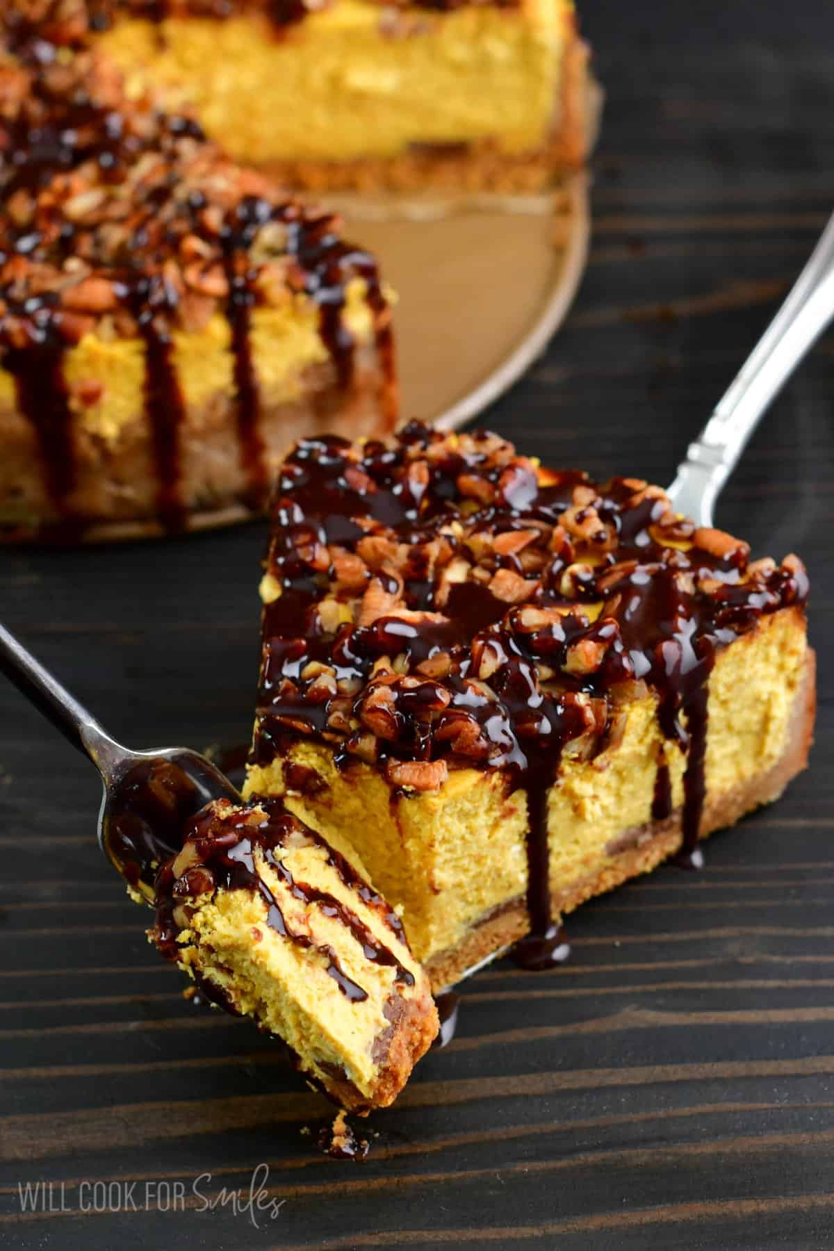 holding a piece of chocolate pumpkin cheesecake on a fork next to a slice.