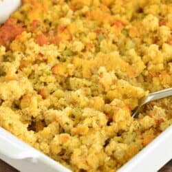 fluffing cooked cornbread dressing in the baking dish.