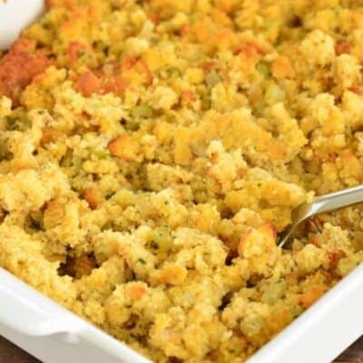 fluffing cooked cornbread dressing in the baking dish.