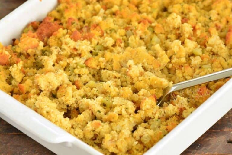 fluffing cooked cornbread dressing in the baking dish.