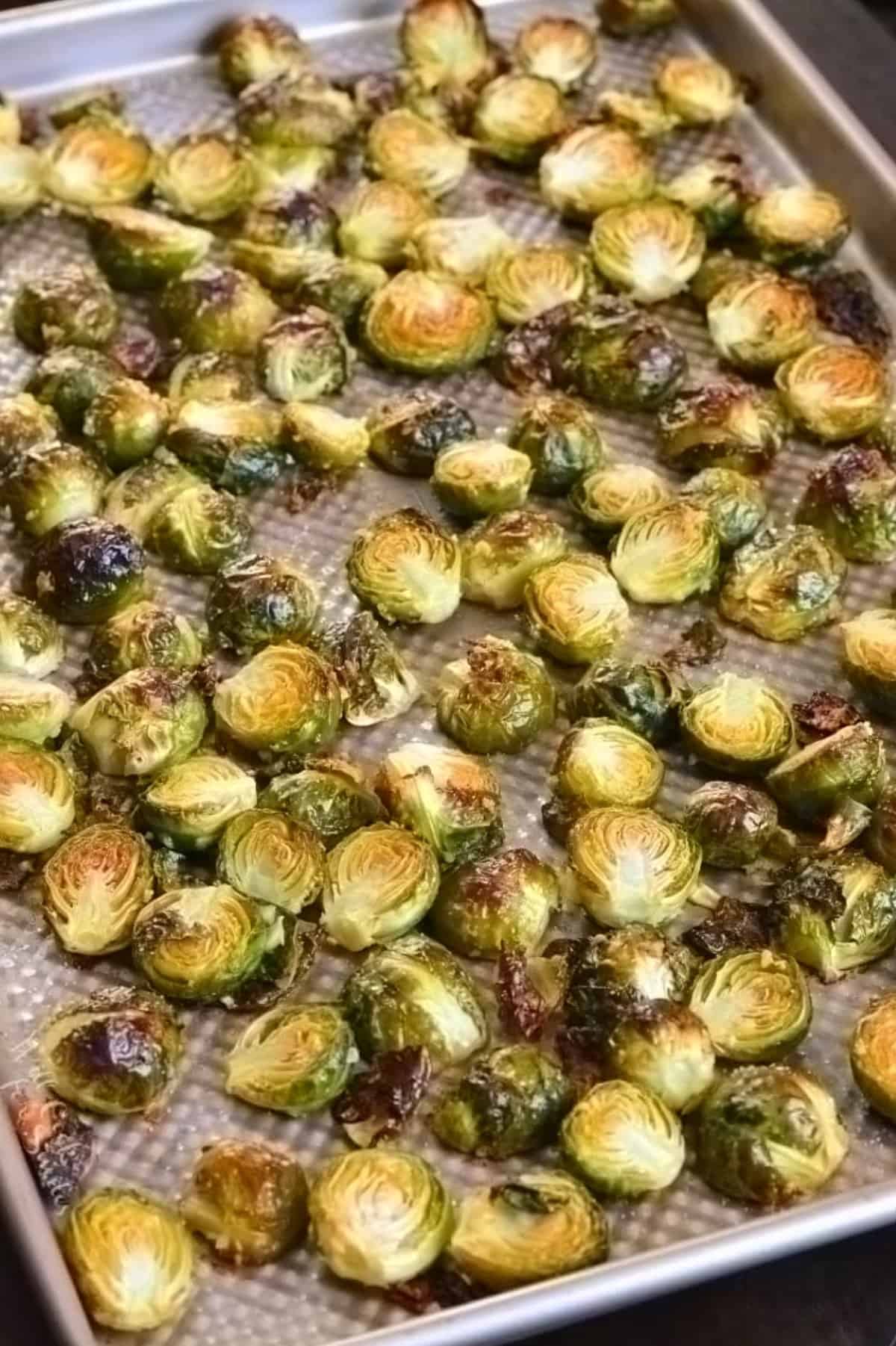 Cooked garlic butter brussels sprouts on a baking sheet.