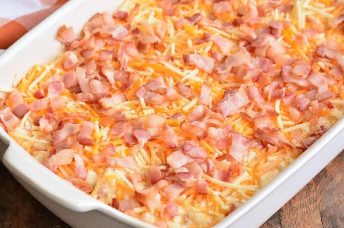 Loaded cheesy potato casserole with bacon on top before baking.