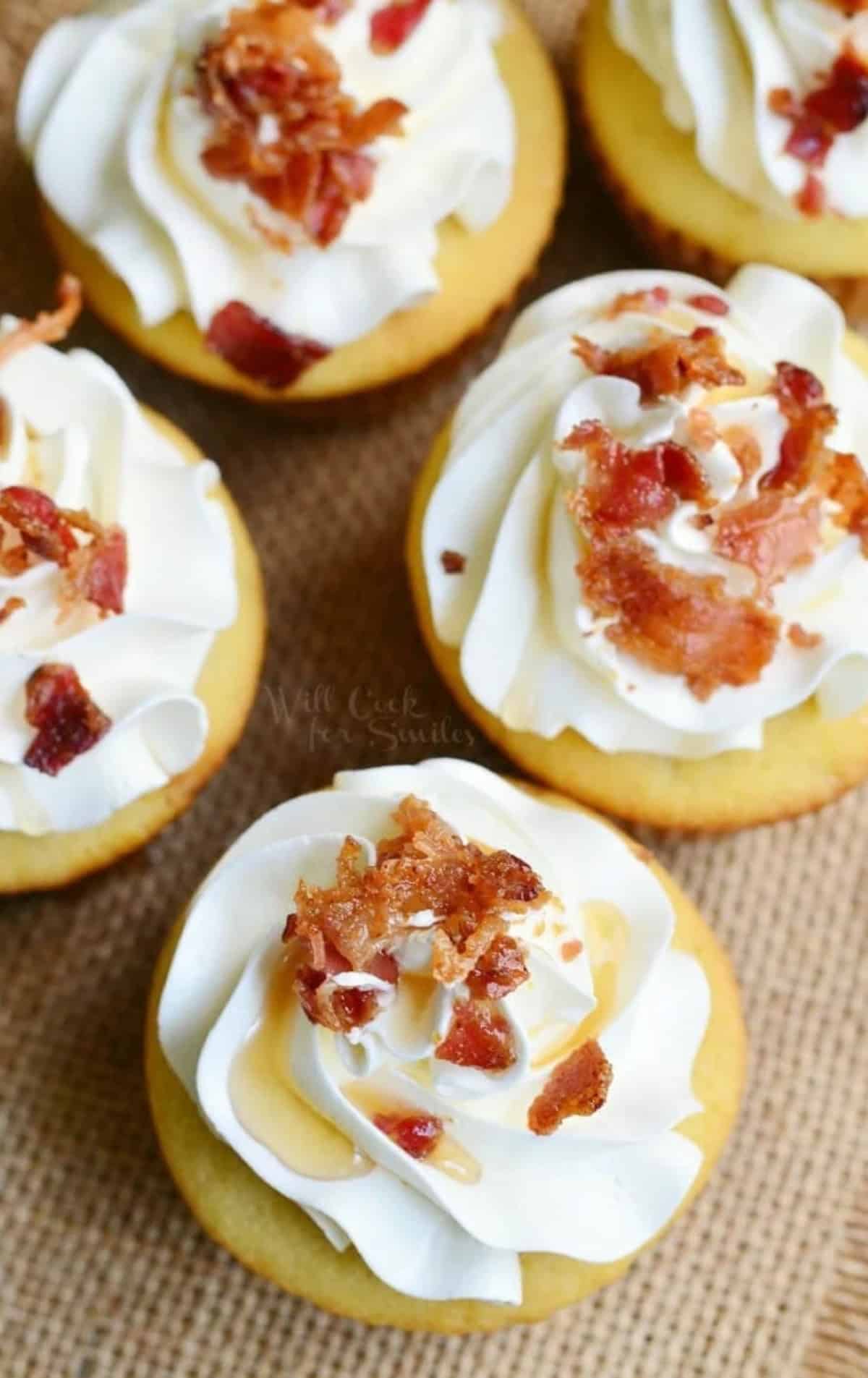 several cupcakes topped with buttercream frosting, maple and bacon.