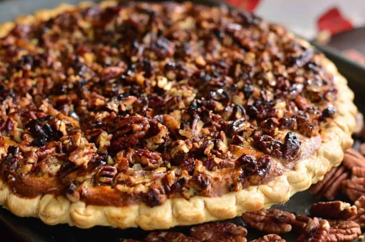 sweet potato pie topped with sweet pecan topping baked on a trey.