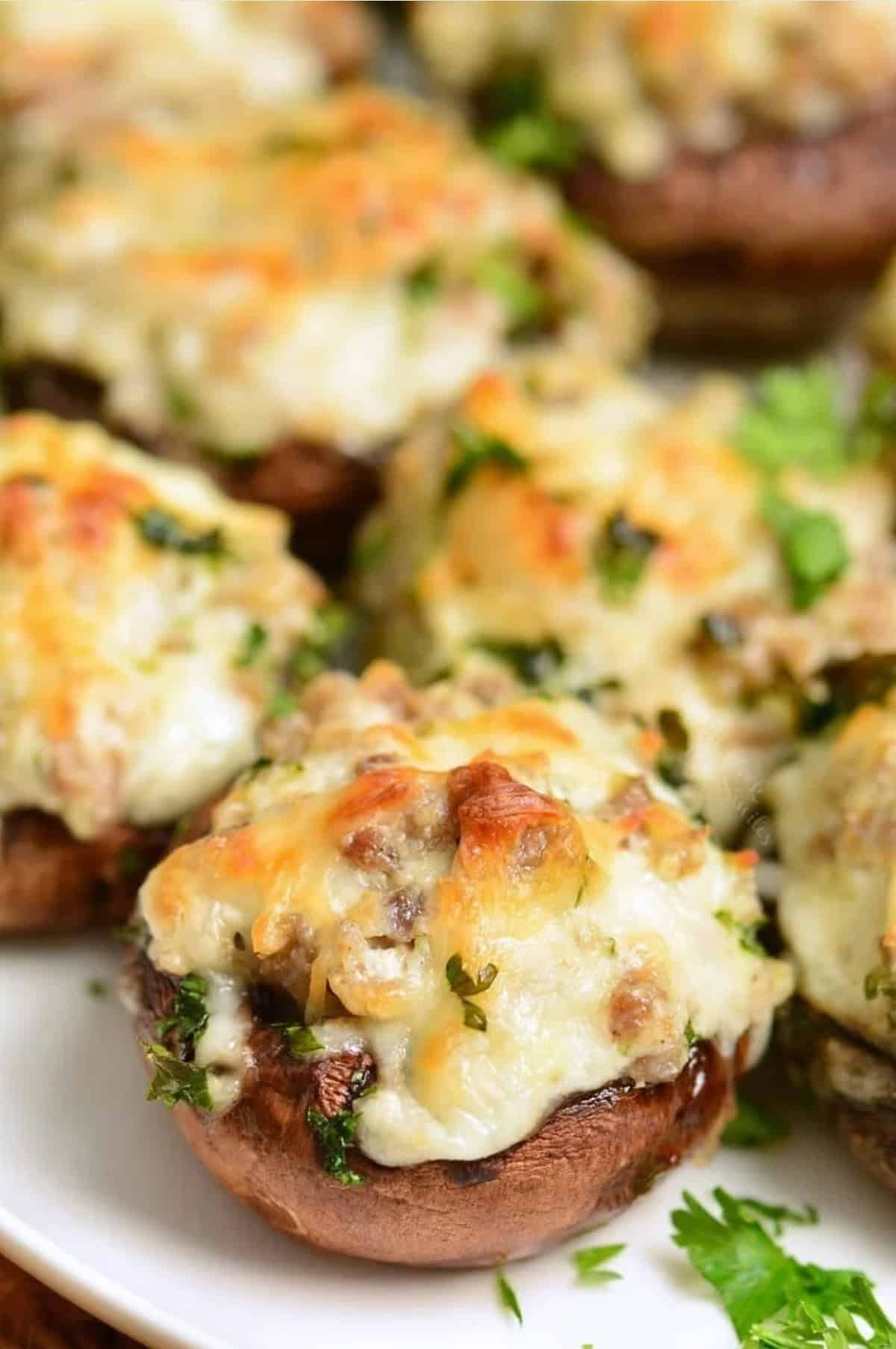 sausage stuffed mushrooms garnished with parsley on the platter.