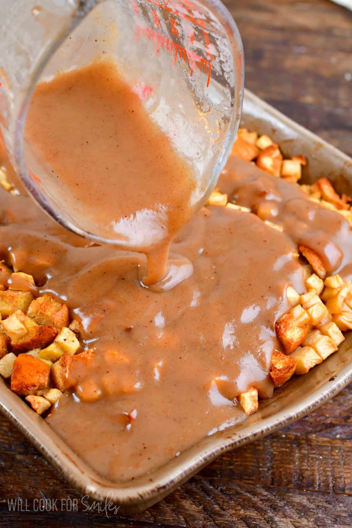 pouring the apple sauce over the apple bread pudding.