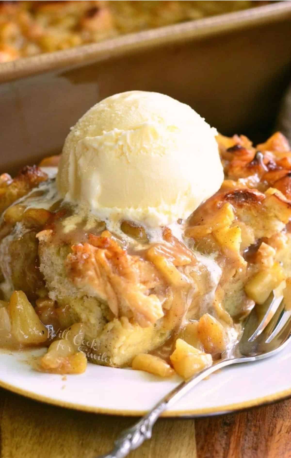 a slice of apple pie bread pudding on the plate with ice cream on top.