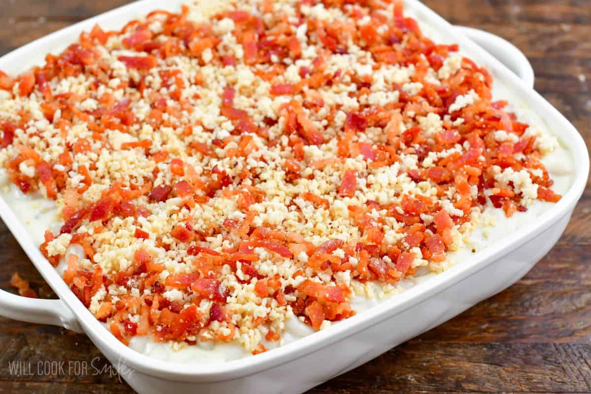 mac and cheese in a white baking dish with bacon panko topping before baking.