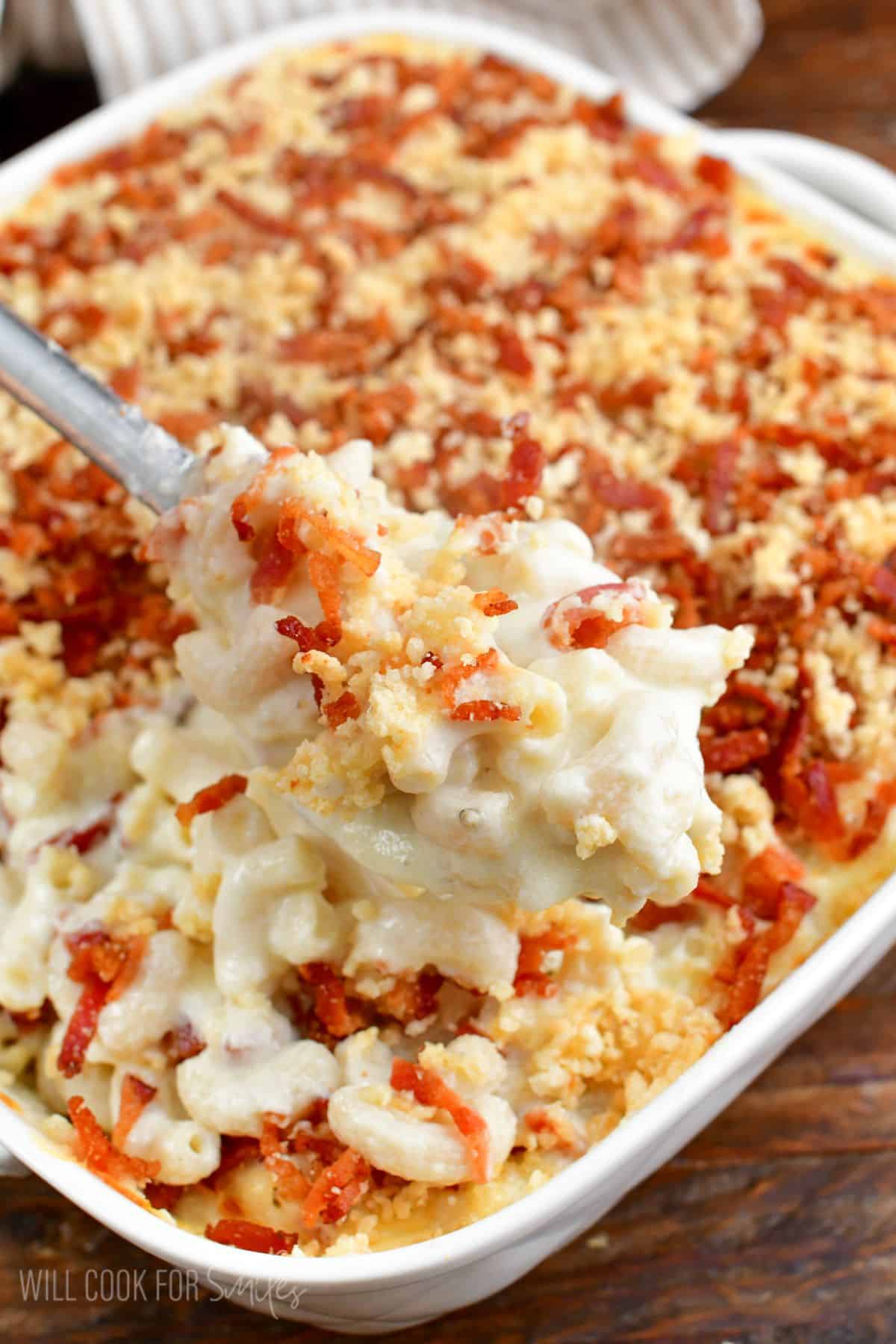 some baked mac and cheese scooped on a silver serving spoon.