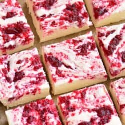 Cranberry White chocolate fudge cut into squares on parchment.