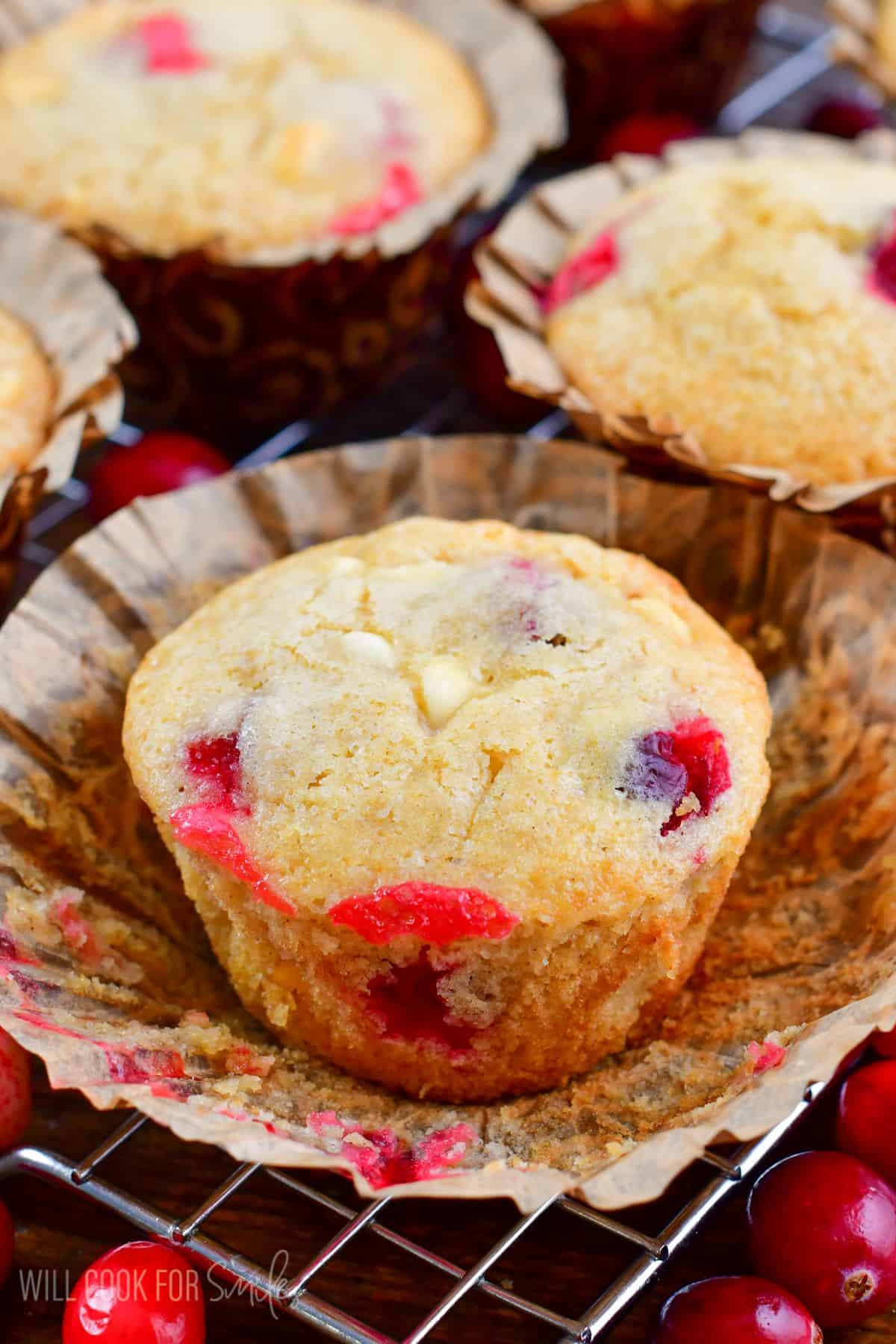 cranberry muffin sitting on the open parchment paper cup.