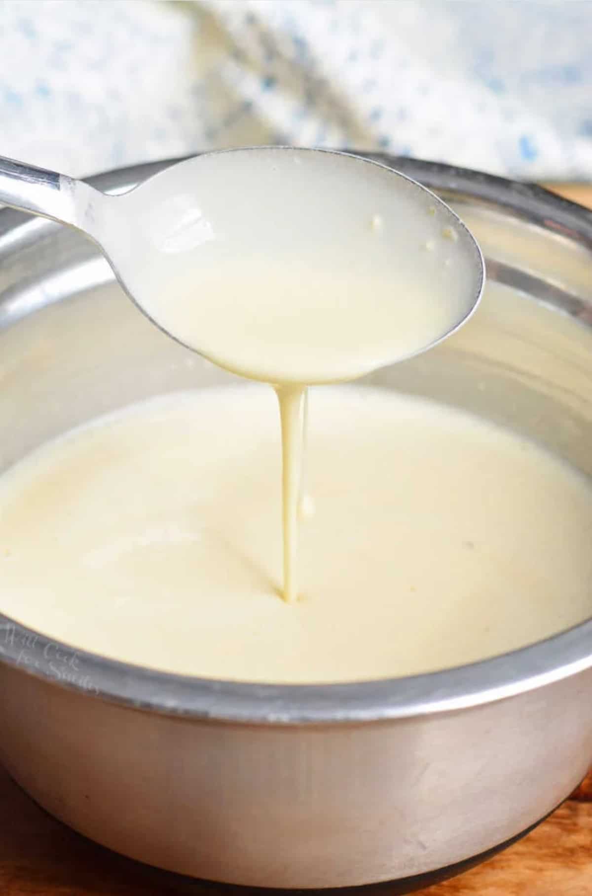 scooping thin crepe batter from mixing bowl.