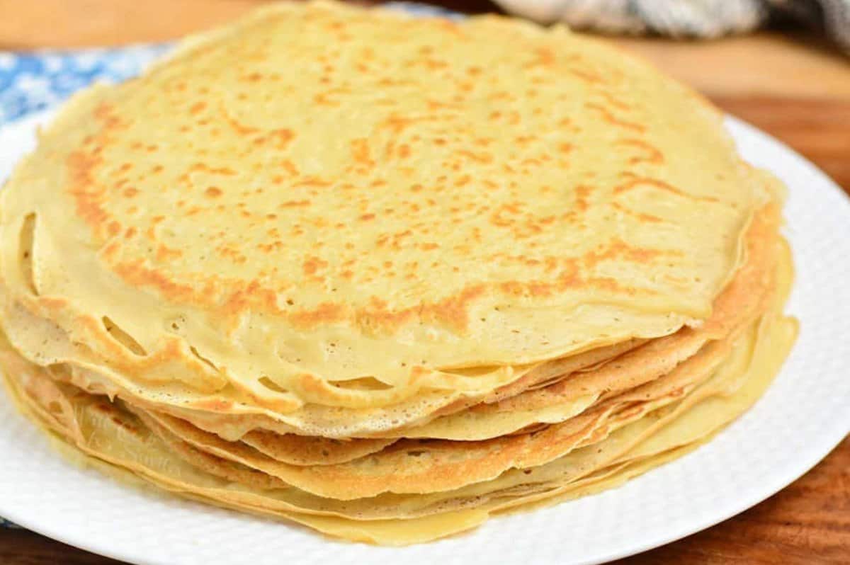 stack of thin crepes on a white plate.