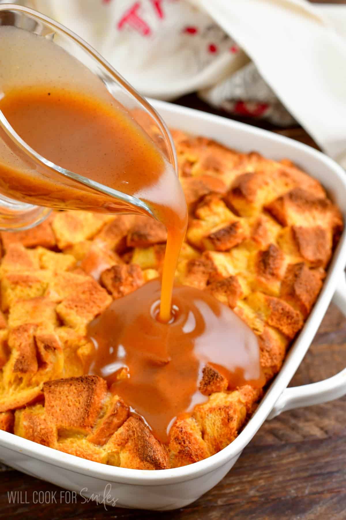 pouring sweet syrup over the baked French toast casserole.