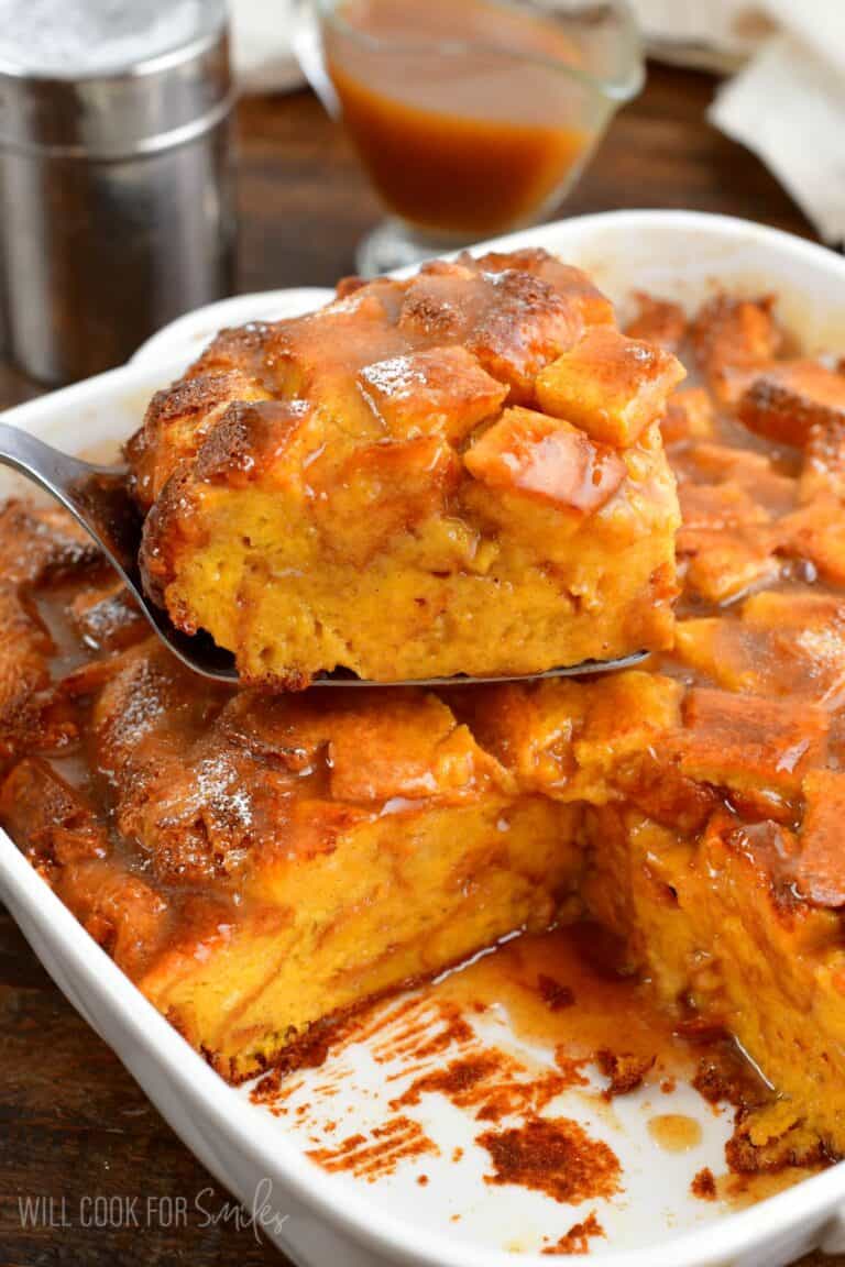 a slice of French toast casserole on top of the rest of the casserole in the baking dish.