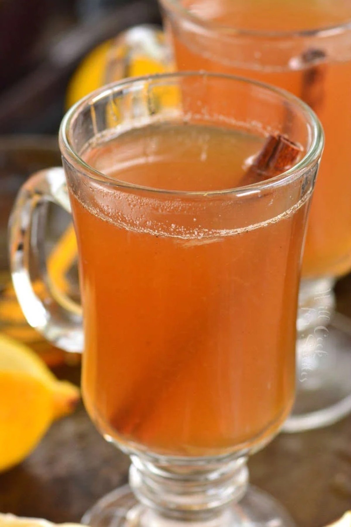 a tall mug with hot toddy and a cinnamon stick.