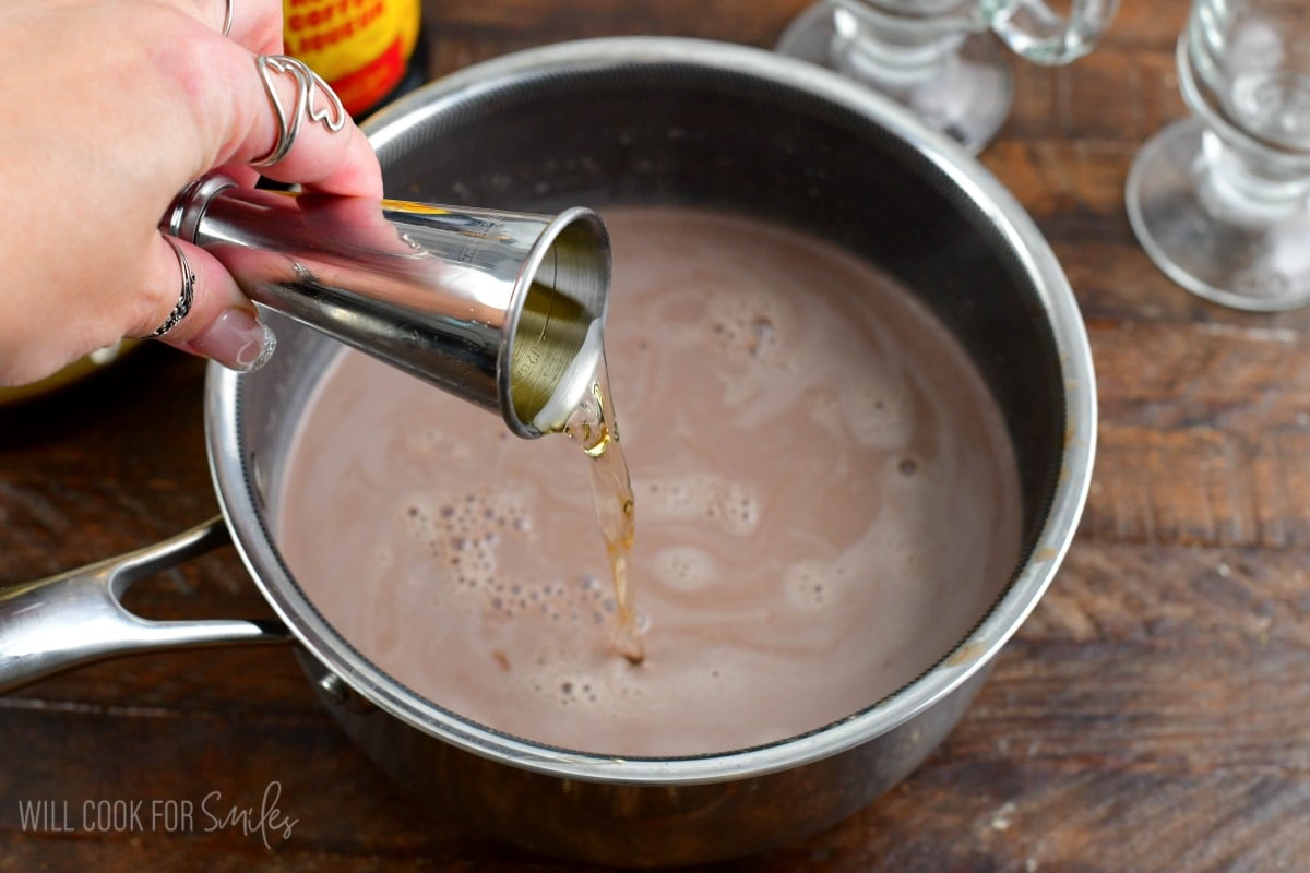 adding frangelico to the nutella hot chocolate in a pot.