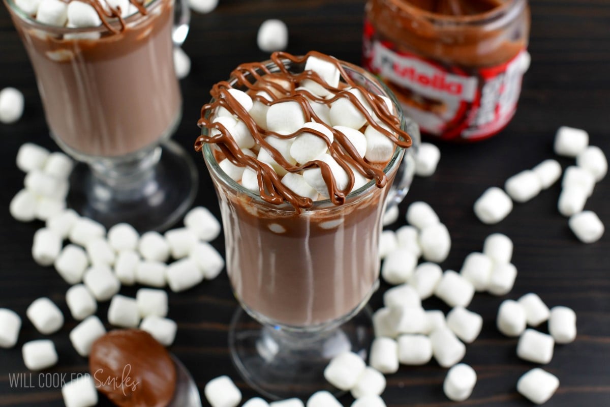 Nutella hot chocolate in a glass with mini marshallows on top and nutella as garnish.