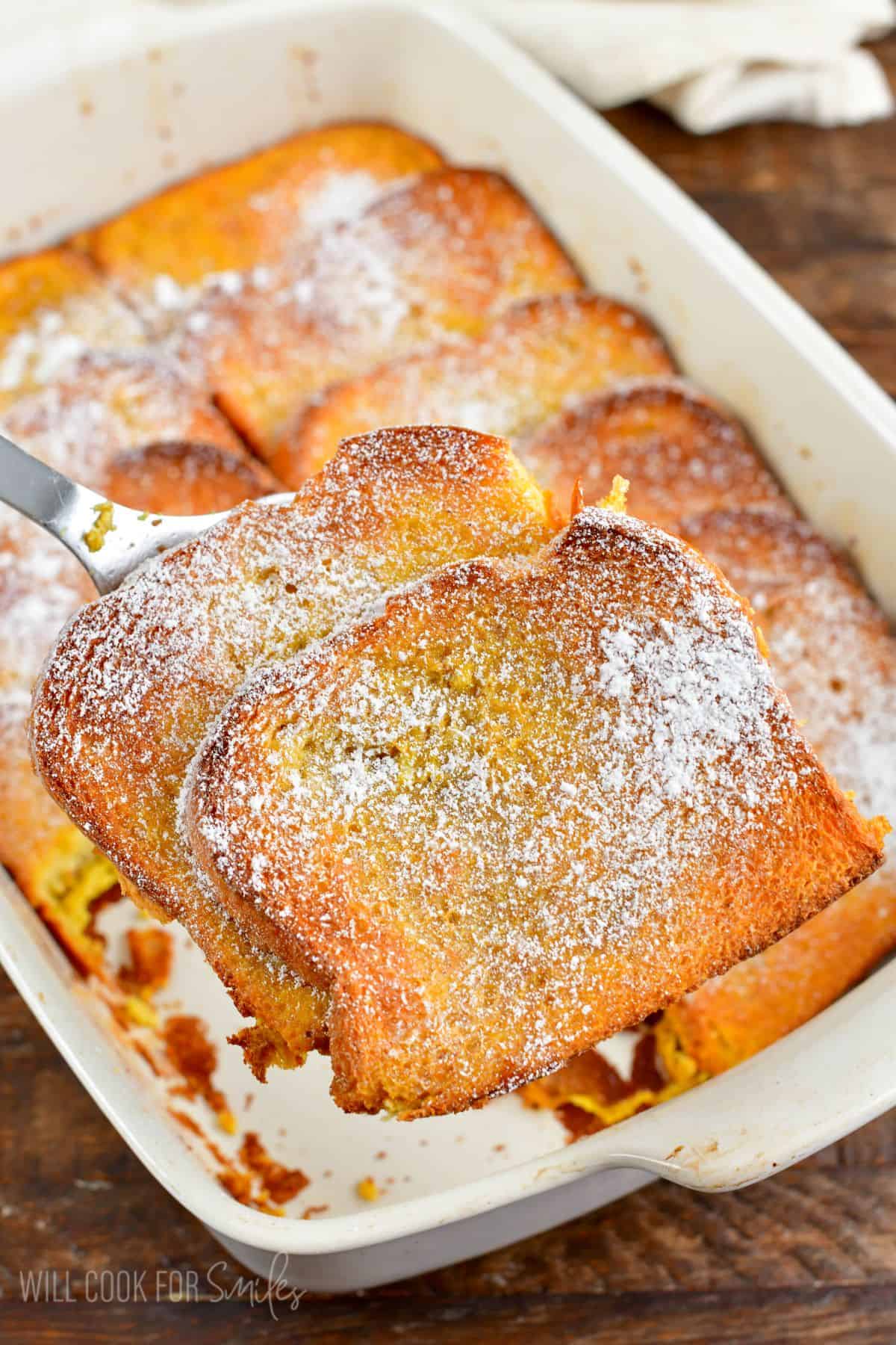 pulling out two slices of French toast bake with a spatula.