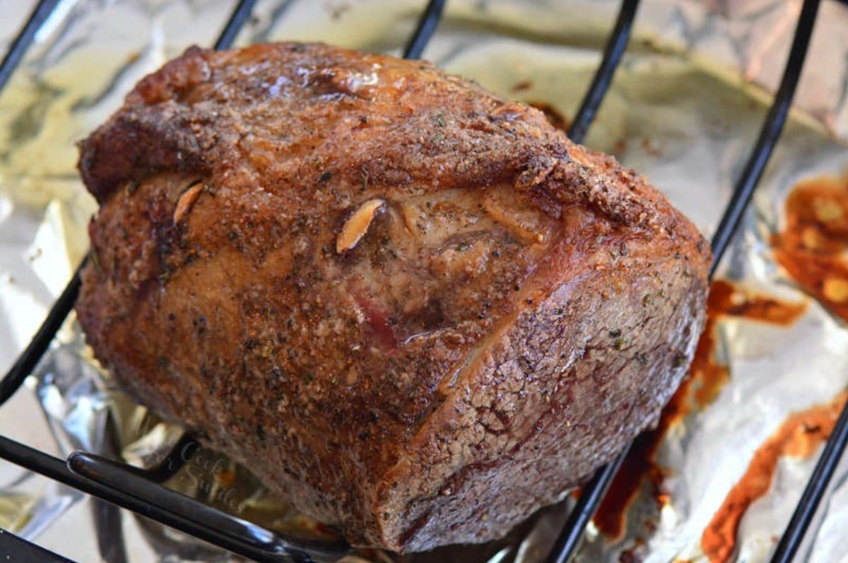 whole roast beef on a wire rack in a roasting pan.