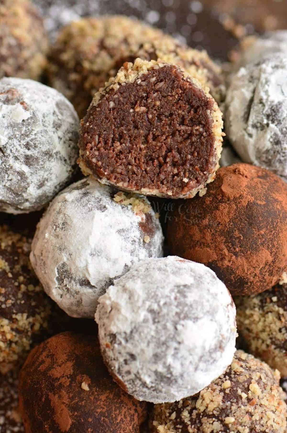 several stacked rum balls with one cut in half to see inside.