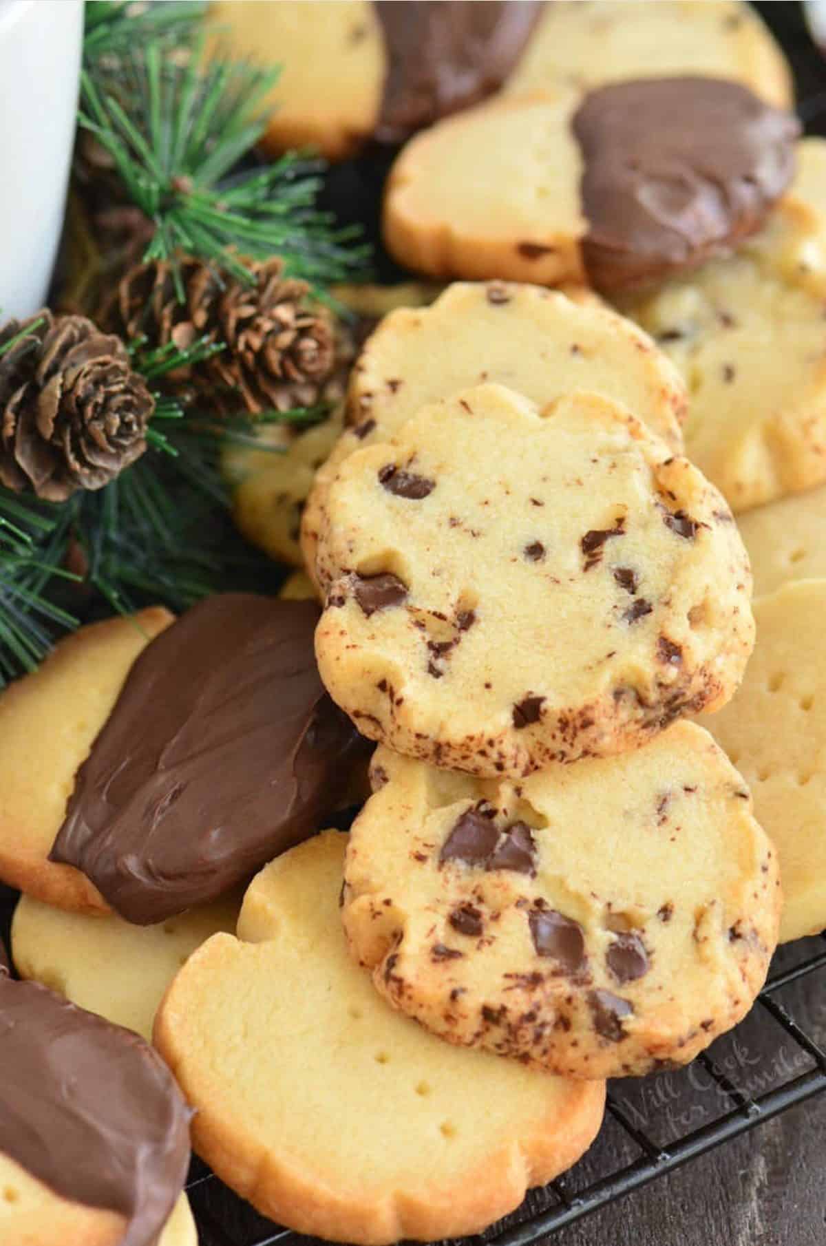 chocolate chunk, chocolate dipped, and plain shortbread cookies piled on a wire rack.